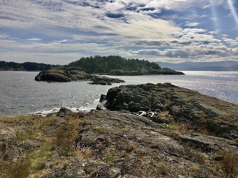 the coastline of two small islands against a cloudy sky.